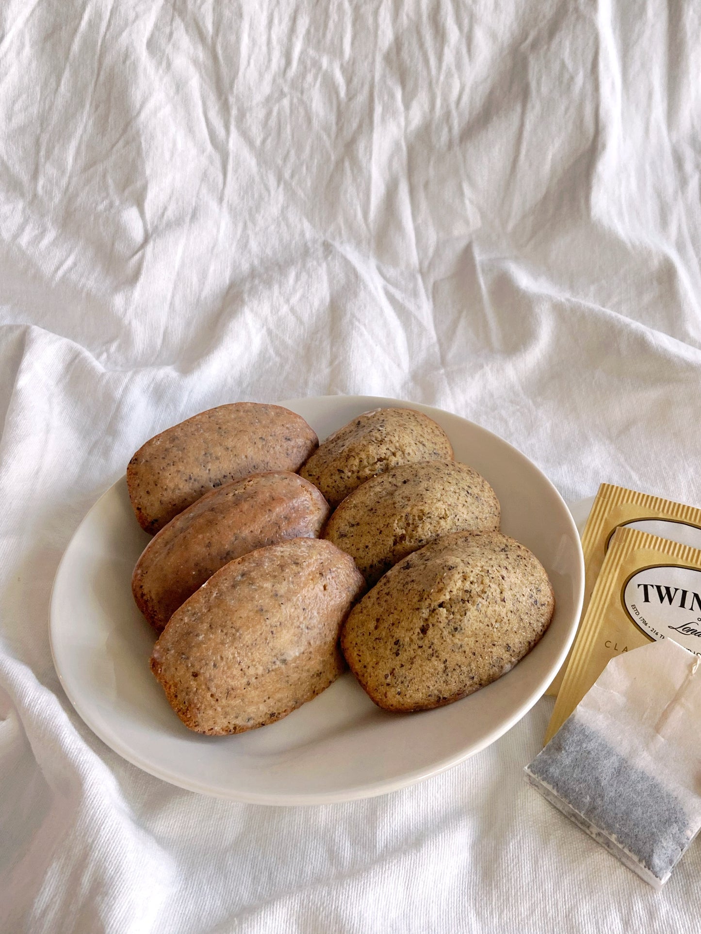 6 Earl Grey Madeleines on white plate and backdrop